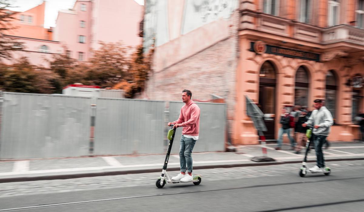 deux hommes roulent à trottinette électrique - unsplash
